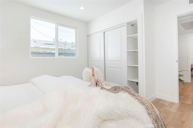 bedroom with a closet and light hardwood / wood-style flooring