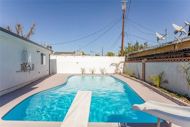 view of swimming pool featuring a diving board