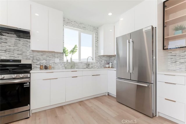 kitchen featuring sink, stainless steel appliances, white cabinetry, and decorative backsplash