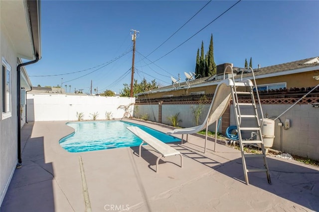 view of pool with a water slide and a patio