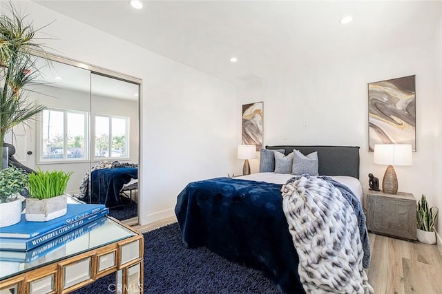 bedroom with light hardwood / wood-style floors and a closet