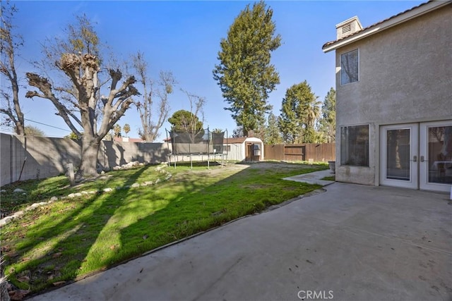 view of yard featuring a patio area, a storage shed, and a trampoline