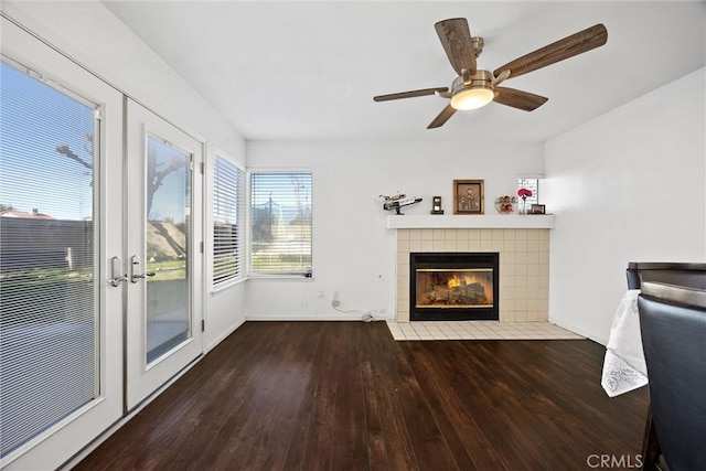 unfurnished living room with ceiling fan, french doors, dark hardwood / wood-style floors, and a fireplace