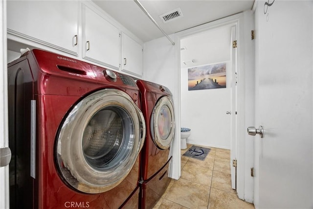 laundry area featuring cabinets, light tile patterned floors, and independent washer and dryer