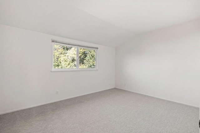 unfurnished room featuring carpet floors and lofted ceiling