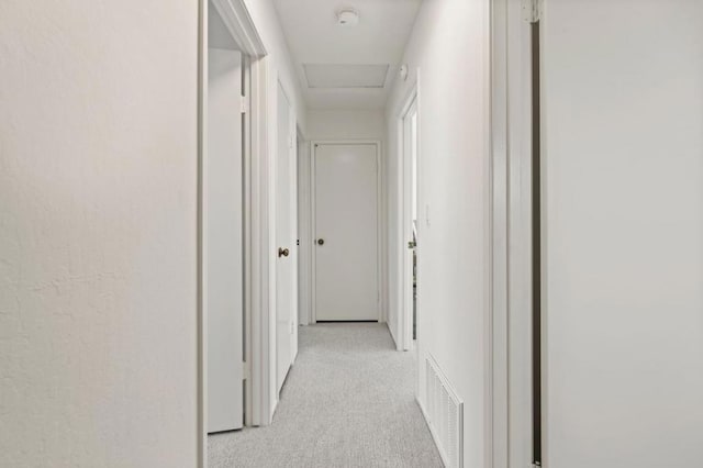 hall with light colored carpet