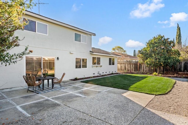 rear view of property with a yard and a patio