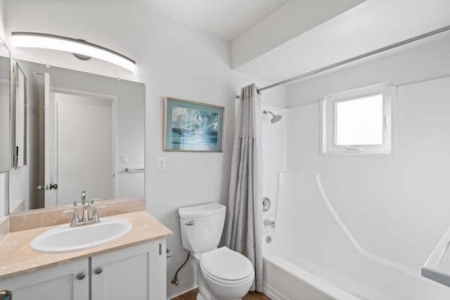 full bathroom featuring toilet, shower / bathtub combination with curtain, and vanity