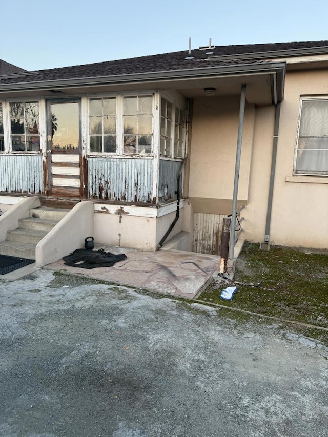 property entrance featuring covered porch and a patio