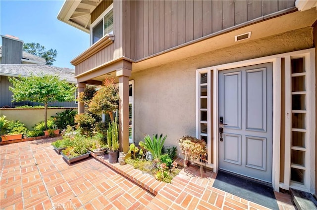 view of exterior entry with a patio area