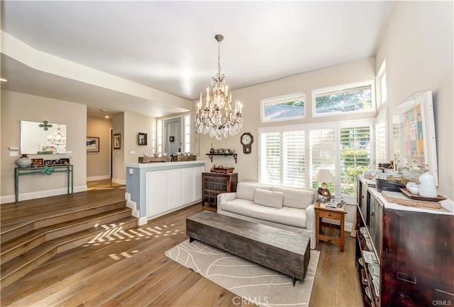 living room with an inviting chandelier and light hardwood / wood-style flooring