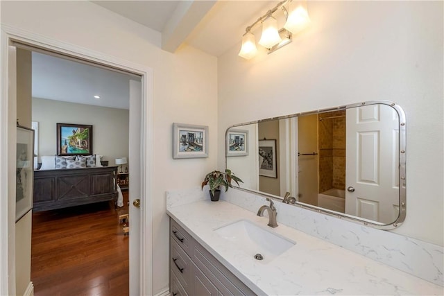 bathroom featuring hardwood / wood-style flooring, vanity, shower / bath combination, and beamed ceiling