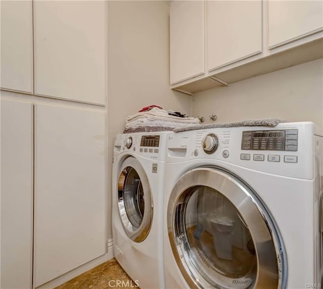 laundry room featuring cabinets, washer and clothes dryer, and light tile patterned floors