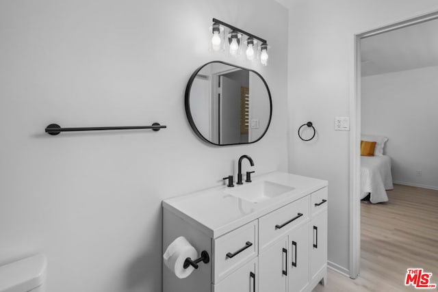 bathroom with vanity, hardwood / wood-style flooring, and toilet