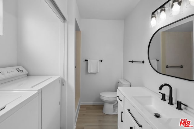 bathroom featuring vanity, hardwood / wood-style flooring, toilet, and independent washer and dryer