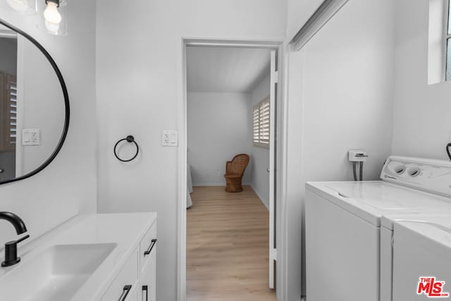 bathroom with washing machine and clothes dryer, hardwood / wood-style floors, and vanity