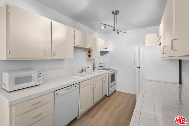 kitchen featuring white appliances, pendant lighting, light hardwood / wood-style floors, sink, and tile countertops