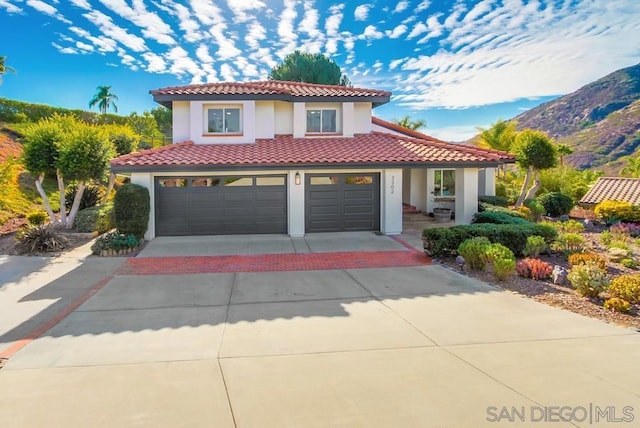 mediterranean / spanish house featuring a garage and a mountain view