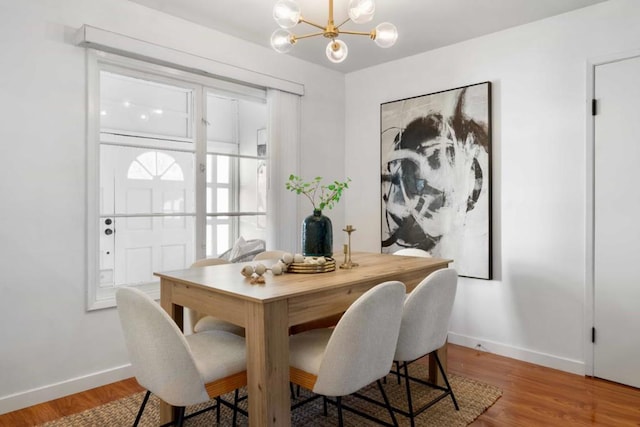 dining space featuring hardwood / wood-style floors and a notable chandelier