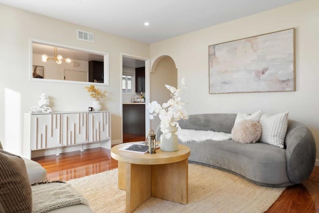 living room with a notable chandelier and hardwood / wood-style flooring