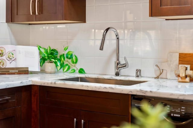 kitchen featuring light stone countertops, dishwasher, sink, and decorative backsplash