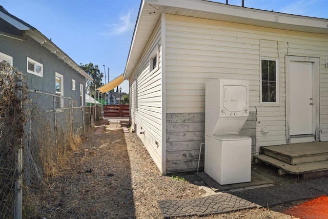 view of side of home featuring stacked washer / dryer