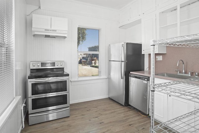 kitchen with crown molding, appliances with stainless steel finishes, sink, white cabinets, and dark hardwood / wood-style floors