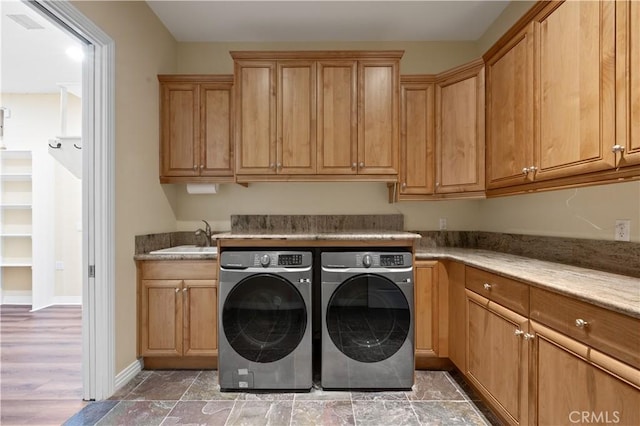 laundry area featuring cabinets, sink, and washer and clothes dryer