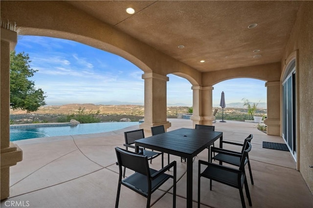 view of patio / terrace featuring a water and mountain view