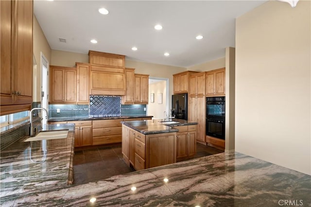 kitchen featuring black appliances, a center island, dark stone counters, tasteful backsplash, and sink