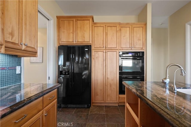 kitchen with black appliances, dark stone countertops, decorative backsplash, and sink