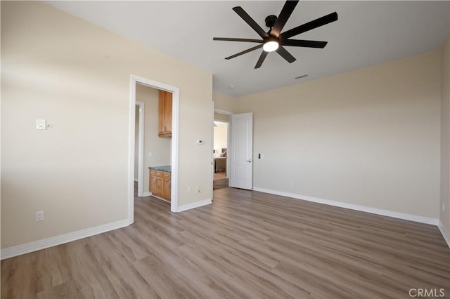 unfurnished bedroom with wood-type flooring, ensuite bath, and ceiling fan