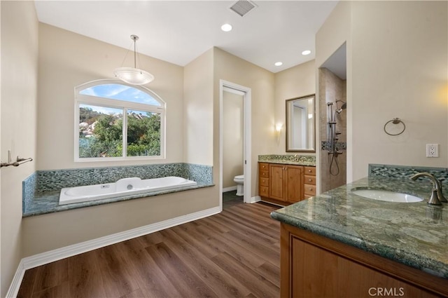 full bathroom featuring vanity, toilet, hardwood / wood-style floors, and plus walk in shower