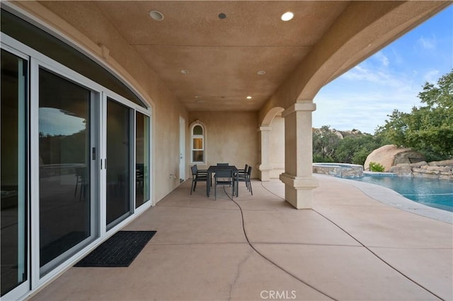 view of patio / terrace featuring a pool with hot tub