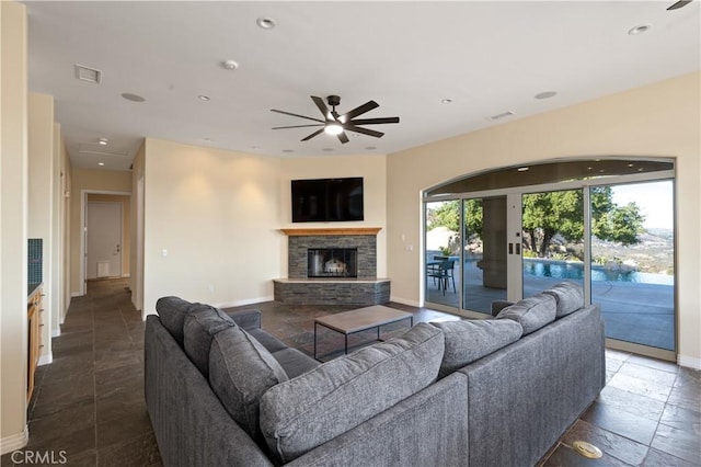 living room featuring a fireplace and ceiling fan