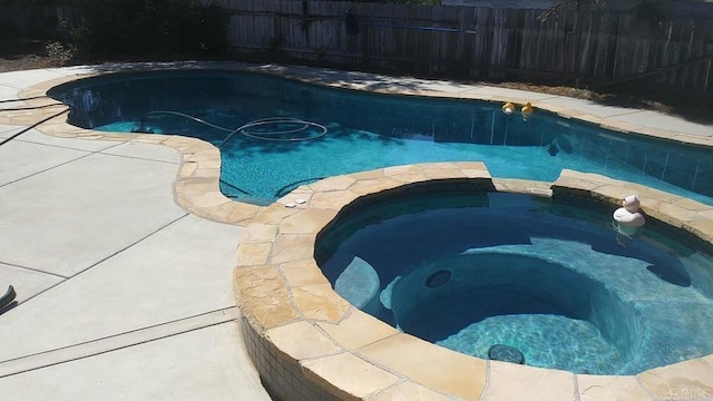 view of swimming pool with an in ground hot tub