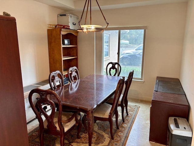 dining space featuring light tile patterned floors and baseboards