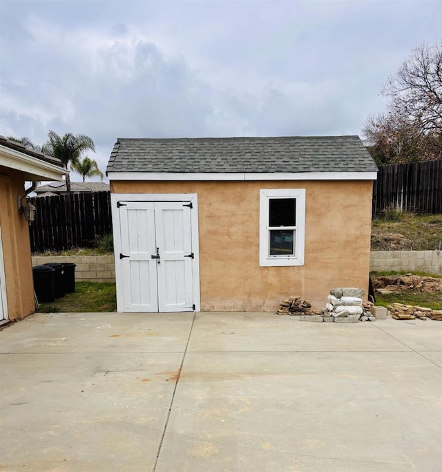 view of outdoor structure featuring an outbuilding and fence