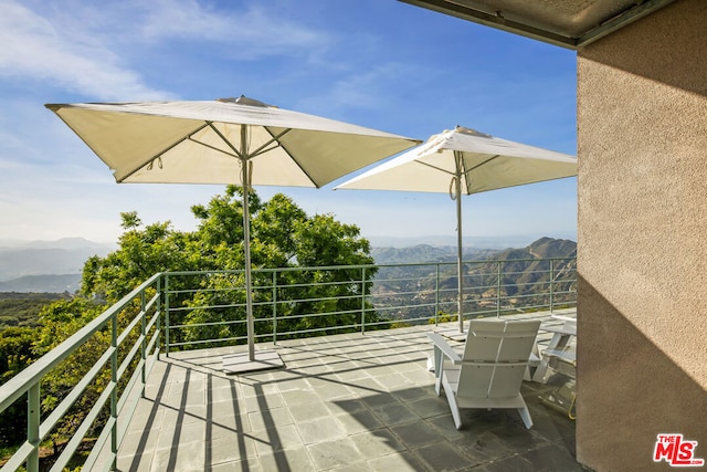 view of patio / terrace with a balcony and a mountain view