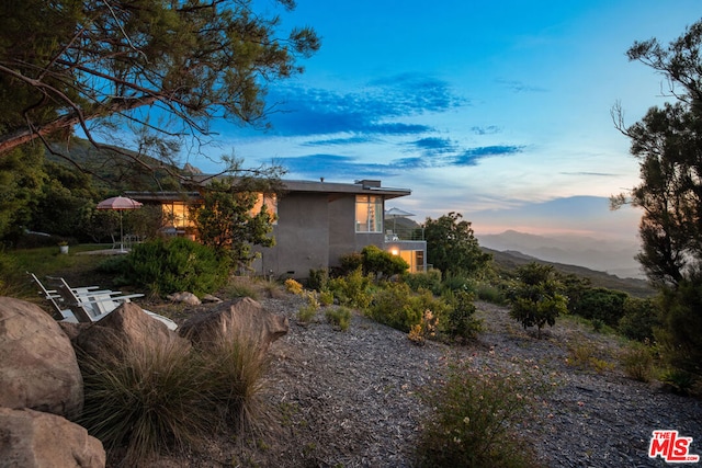 property exterior at dusk with a balcony and a mountain view