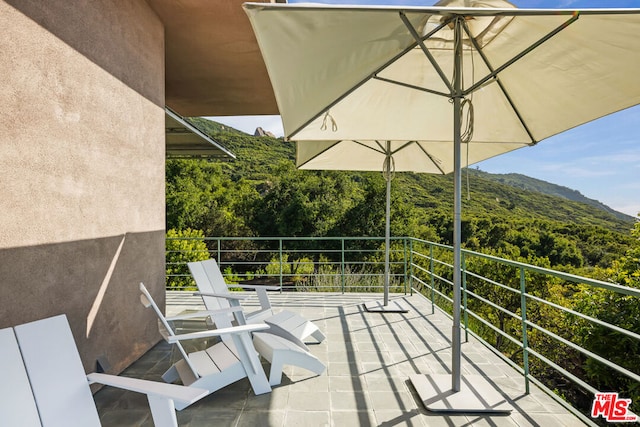 view of patio / terrace with a balcony and a mountain view