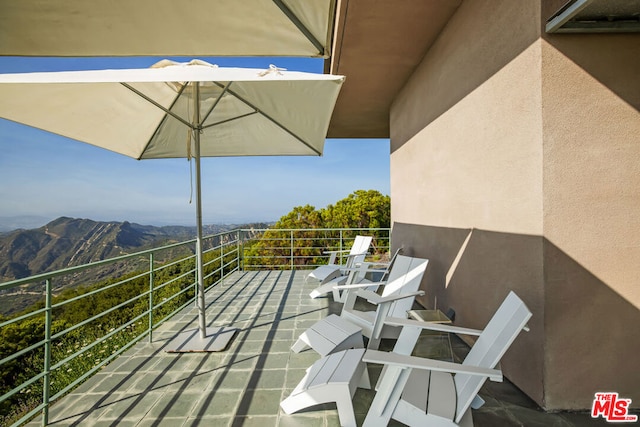 view of patio / terrace with a balcony and a mountain view