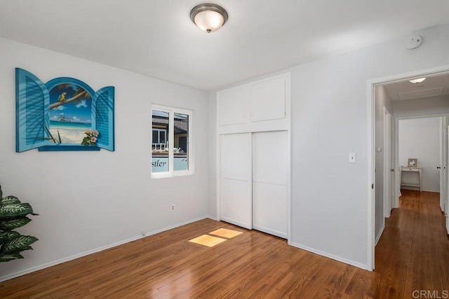 unfurnished bedroom with wood-type flooring and a closet