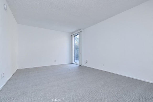 carpeted empty room featuring a textured ceiling