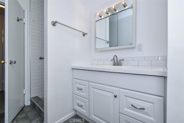 bathroom with vanity and a tile shower