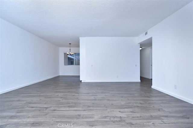 interior space featuring a notable chandelier, a textured ceiling, and dark hardwood / wood-style flooring