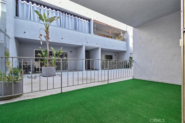 back of property with a balcony and stucco siding