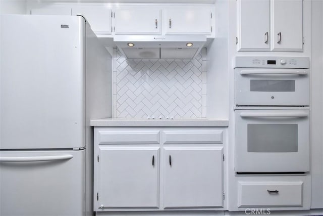 kitchen with light countertops, white appliances, and white cabinets