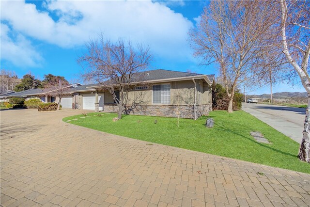 ranch-style home featuring a garage and a front lawn