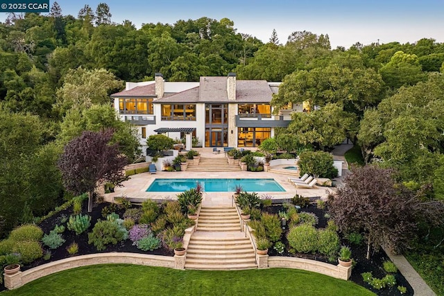 back of house with a balcony and a lawn